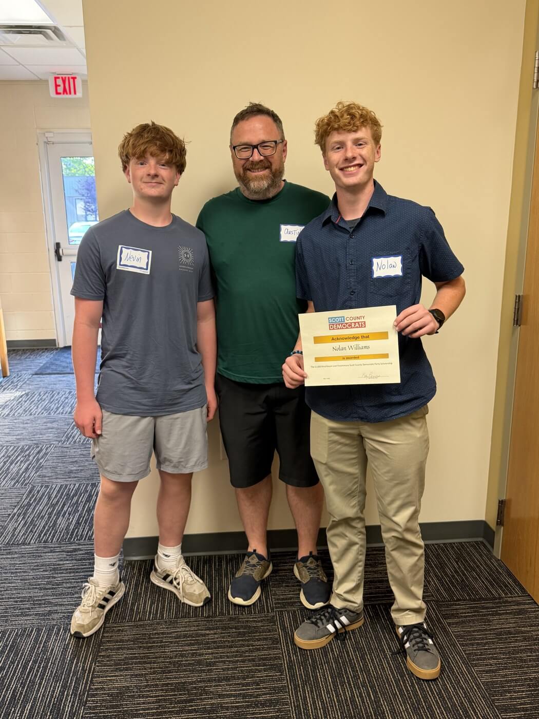 2026 scholarship recipient Nolan Williams holding his certificate with his brother Nevin and father Austin